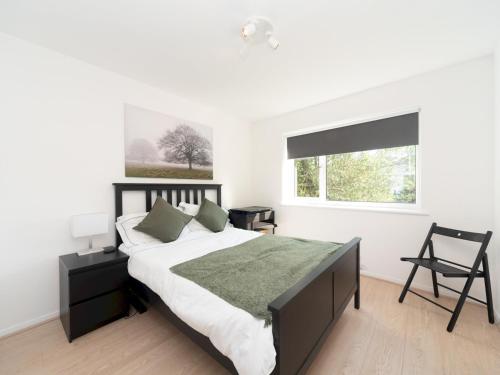 Un dormitorio con una cama grande y una ventana en Pass the Keys Chic apartment amazing location, en Teddington