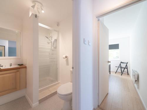 een witte badkamer met een toilet en een douche bij Pass the Keys Chic apartment amazing location in Teddington