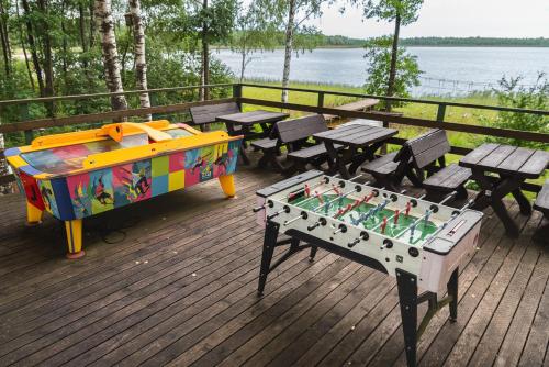 a table and benches with a board game on a deck at Senelio Romo Sodyba in Molėtai