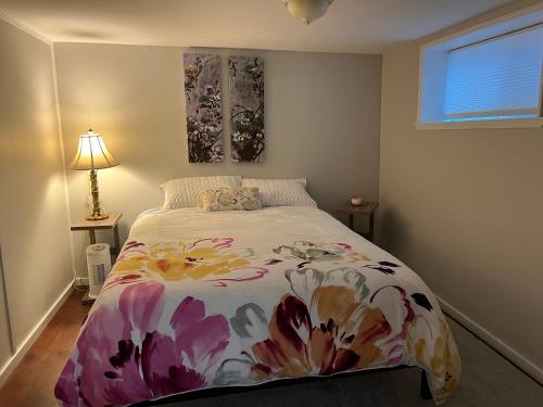 1 dormitorio con 1 cama con colcha de flores en River house, en Campbell River