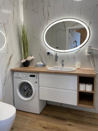 een badkamer met een wasmachine en een spiegel bij Perlowa Przystan - Apartamenty KOMFORT widok na morze, parking in Sianozety