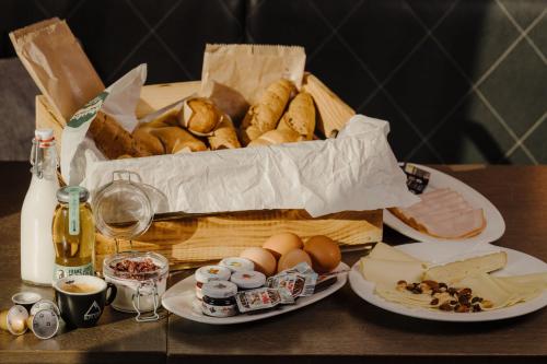 una cesta de pan y bollería en una mesa en AvenidA Mountain Lodges Kaprun, en Kaprun