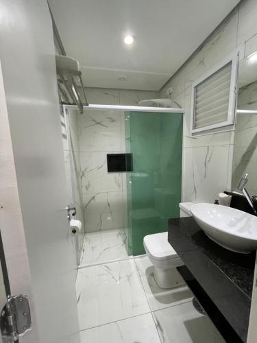 a bathroom with a sink and a toilet and a shower at Riviera Flat 120 - Com serviços de hotelaria in Riviera de São Lourenço
