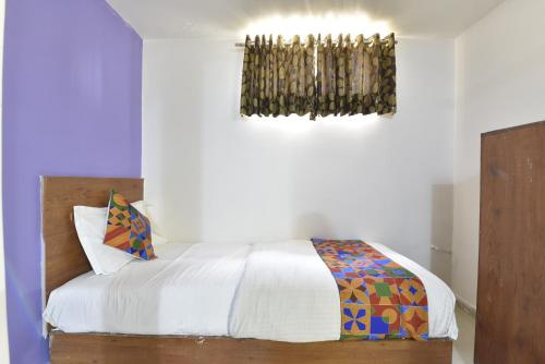 um quarto com uma cama com lençóis brancos e uma janela em HOTEL GOLD LEAF em Ahmedabad