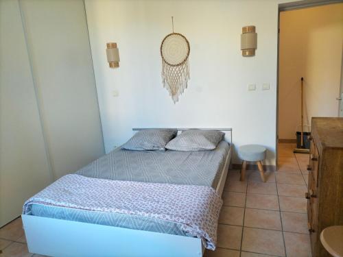 - une petite chambre avec un lit et une chaise dans l'établissement Entre Voyages et Occitanie, à Vers-Pont-du-Gard