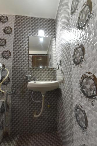 uma casa de banho com um lavatório e um espelho em HOTEL GOLD LEAF em Ahmedabad