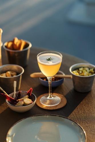 a table topped with a drink and bowls of food at Paradise Relais Villa Janto' in Ischia
