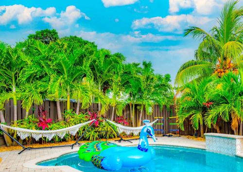 a pool at a resort with a mermaid on a raft at Colorful Home - Pool - Game Room - Basketball Court - BBQ & More in Fort Lauderdale