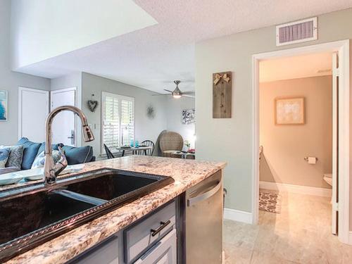 a kitchen with a sink and a living room at Stunning Tree Tops Apt - Disney! in Kissimmee