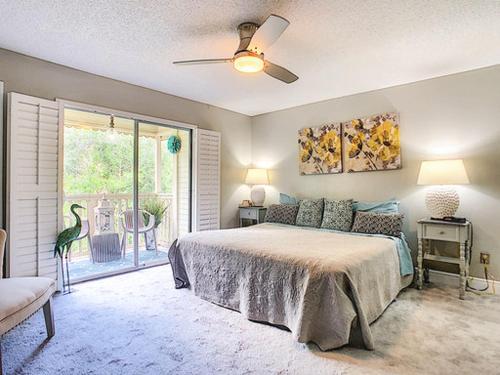 1 dormitorio con cama y ventana grande en Stunning Tree Tops Apt - Disney! en Kissimmee