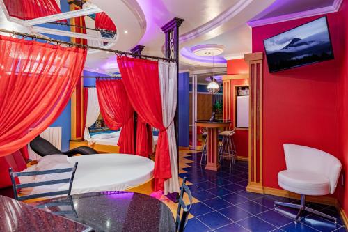 a living room with red curtains and a tv at Monn Cherry Motel in Lajeado