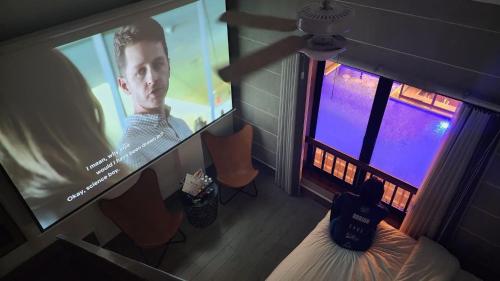 uma sala com um grande ecrã de projecção num quarto em Urban Glamp Resort em Oton