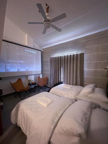 a hotel room with two beds and a projection screen at Urban Glamp Resort Iloilo in Oton