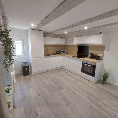 a kitchen with white cabinets and a wooden floor at EDEN in Durrenentzen