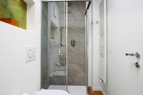 La salle de bains est pourvue d'une douche en verre et de toilettes. dans l'établissement La casa di Marco, à Cavalese