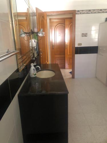 a bathroom with a black counter and a sink at Camere Villa Lella in Policoro