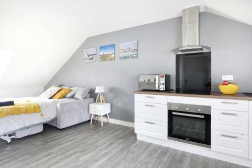 une chambre avec un lit et une cuisine dans l'établissement Phare de Gatteville - Second Souffle - Cherbourg, à Cherbourg en Cotentin
