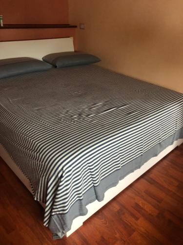 uma cama com um edredão preto e branco em Casa Carly em Macchia
