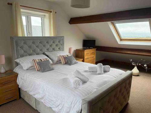Oak Tree Cottage - Pendle - Forest of Bowland في بيرنلي: غرفة نوم بسرير كبير عليها شراشف ووسائد بيضاء