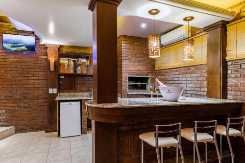 eine Bar in einem Zimmer mit Ziegelwand in der Unterkunft Monn Cherry Motel in Lajeado