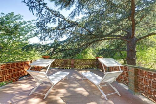 two chairs sitting on a patio under a tree at Pratolina in Savona