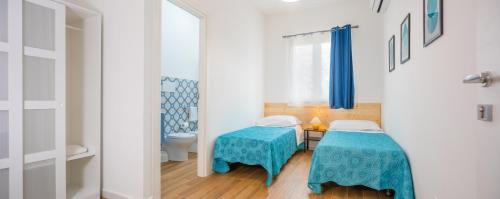 a small room with two tables and a toilet at Arricàmpati Rooms in Villa & RENT CAR Airport in Carini