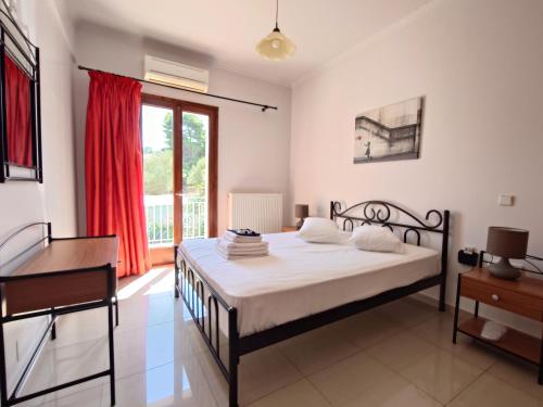 een slaapkamer met een bed, een bureau en een raam bij Iris Apartments Ithaca in Vathi