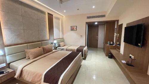 Habitación de hotel con 2 camas y TV de pantalla plana. en HOTEL VAHINI GRAND, en Bhavāni