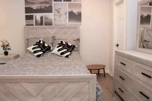 1 dormitorio con 1 cama con almohadas blancas y negras en Modern 1BR Exclusive Space in Historic Brooklyn en Brooklyn