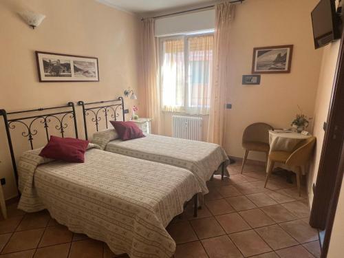 a bedroom with two beds and a table and a window at Il Timone Loreto in Monterosso al Mare