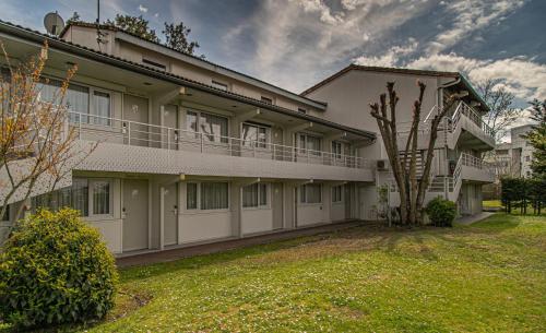 - un grand bâtiment avec un balcon et une cour dans l'établissement Campanile Toulouse - Blagnac Aéroport, à Blagnac