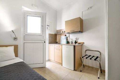 a bedroom with a bed and a small kitchen at Papatsas Center Houses in Nydri
