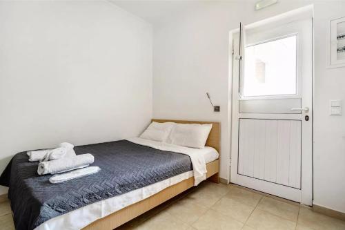 a small bedroom with a bed and a window at Papatsas Center Houses in Nydri