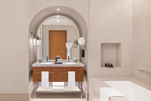 Vida Creek Beach Hotel في دبي: حمام مع حوض ومرآة