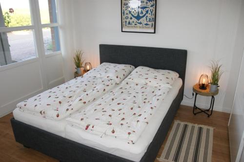ein Schlafzimmer mit einem Bett mit einer weißen Bettdecke in der Unterkunft Sprotte in Schönberger Strand