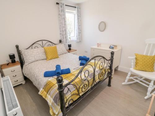 a bedroom with a bed and a desk and a chair at 5 West Winds in Eyemouth