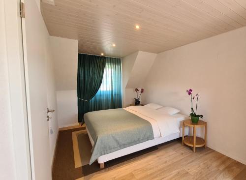 ein kleines Schlafzimmer mit einem Bett und einem Fenster in der Unterkunft Milladon Logement en face de l'EPFL in Ecublens