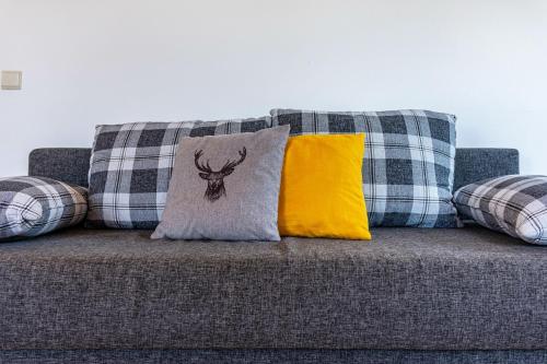 a couch with pillows and a deer pillow on it at Mongaduierhof Apt Panorama in Umes