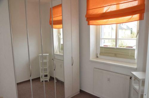 ザスニッツにあるVilla Johanna mit herrlichem Seeblickの窓2つとオレンジのカーテンが備わるお部屋