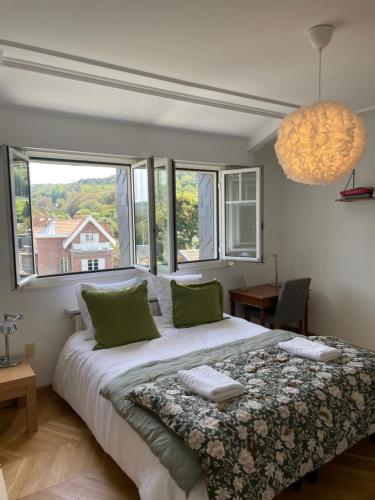 une chambre avec un grand lit avec des oreillers verts dans l'établissement Magnifique appartement à Etretat, à Étretat