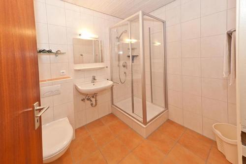 a bathroom with a shower and a toilet and a sink at Feriendorf Reichenbach - Wieselweg 5 in Nesselwang