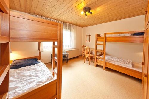 a bedroom with two bunk beds and a desk at Feriendorf Reichenbach - Wieselweg 5 in Nesselwang