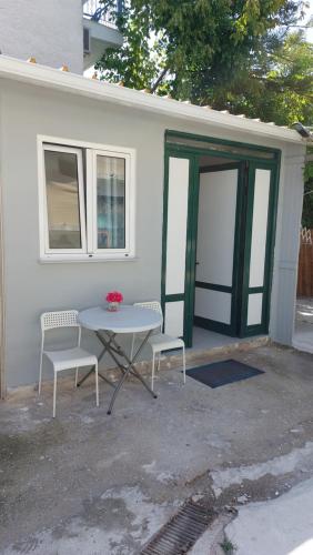 a table and two chairs in front of a building at ESCAPE in Nydri