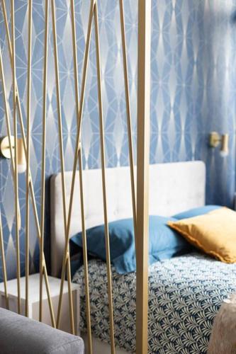 une chambre avec un lit aux murs bleus dans l'établissement Chaudron/La Fayette Canal St-Martin Cosy Studio 4P, à Paris