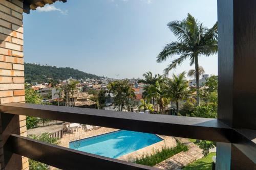 a view from the balcony of a house with a swimming pool at Pousada Albacora in Bombinhas