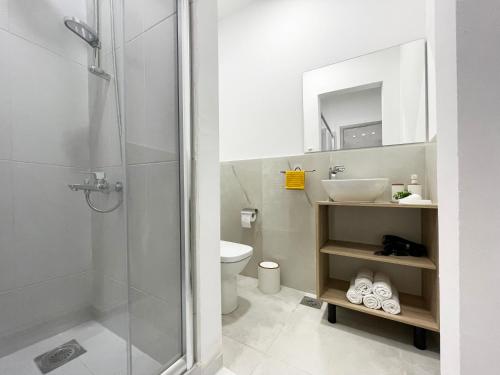 uma casa de banho com um chuveiro, um lavatório e um WC. em Elite Central Suites em Skopje