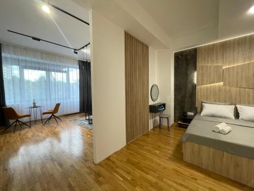 um quarto com uma cama, uma mesa e cadeiras em Elite Central Suites em Skopje
