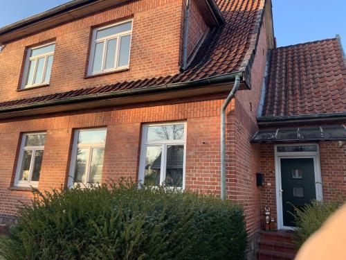 a red brick house with a black door at Fewo Urlaubsspaß in Walsrode