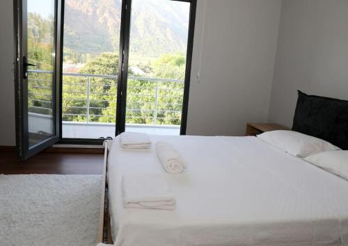 1 dormitorio con cama blanca y ventana grande en Villa Green, en Muğla