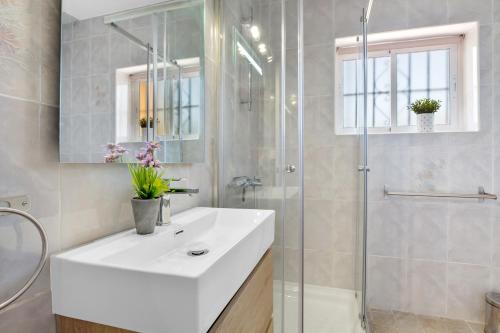 La salle de bains est pourvue d'un lavabo blanc et d'une douche. dans l'établissement Bellamar By IVI Real Estate, à Torremolinos